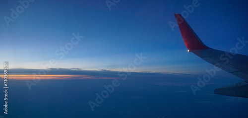 wing of an airplane flying above clouds