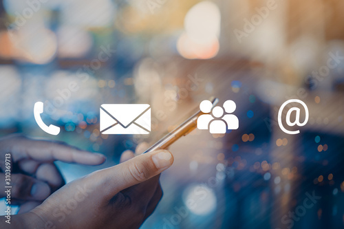 Contact us or Customer support hotline people connect. Businessman using a mobile phone with the (email, call phone, mail) icons.