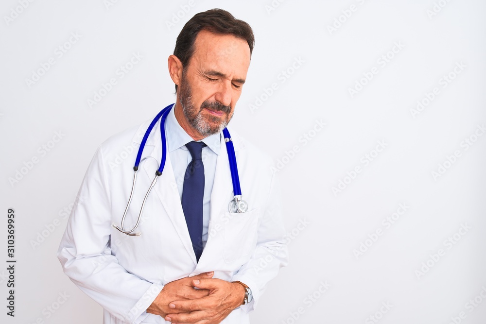 Middle age doctor man wearing coat and stethoscope standing over isolated white background with hand on stomach because indigestion, painful illness feeling unwell. Ache concept. Middle age doctor man wearing coat and stethoscope standing over isolated white background with hand on stomach because indigestion, painful illness feeling unwell. Ache concept.