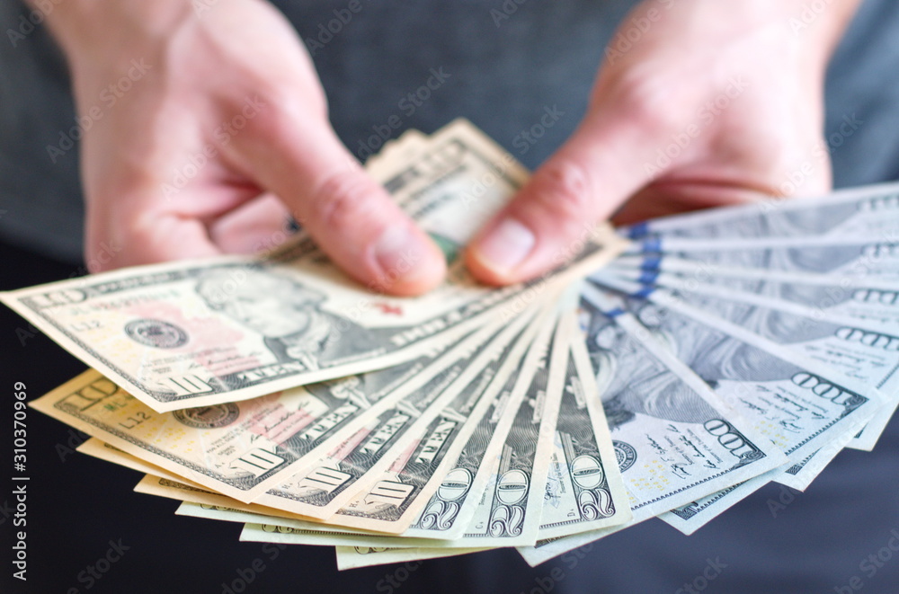 Midsection of man holding dollar banknotes Midsection of man holding dollar banknotes