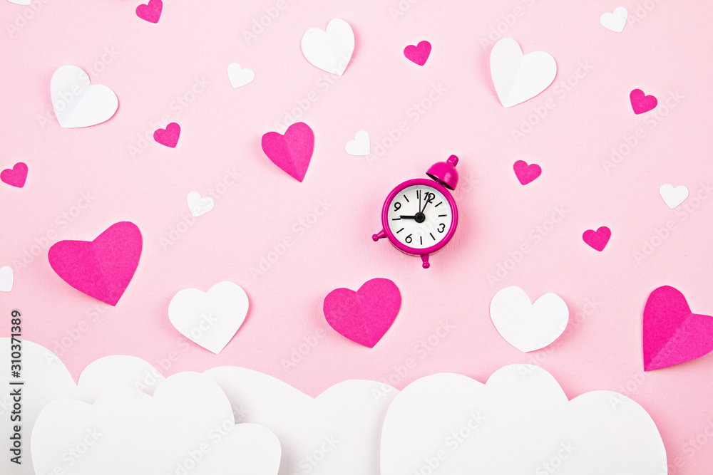 Paper hearts and alarm clock over the pink pastel background. Love, Sainte Valentine, mother's day, birthday greeting cards, invitation, celebration concept Paper hearts and alarm clock over the pink pastel background. Love, Sainte Valentine, mother's day, birthday greeting cards, invitation, celebration concept