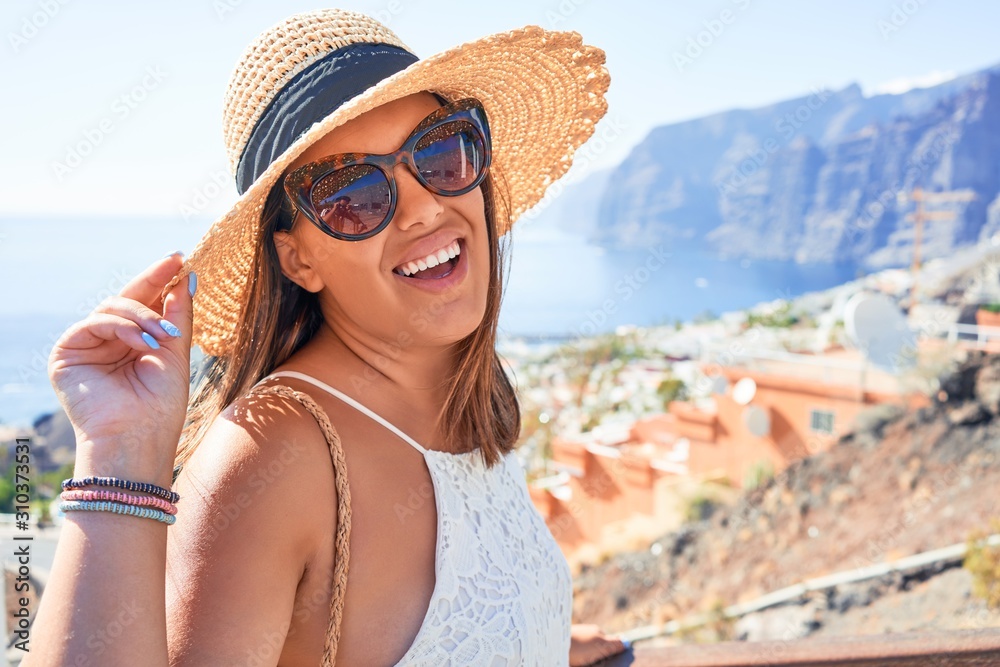 Beautiful young woman walking on beach promenade enjoying ocean view smiling happy on summer vacation