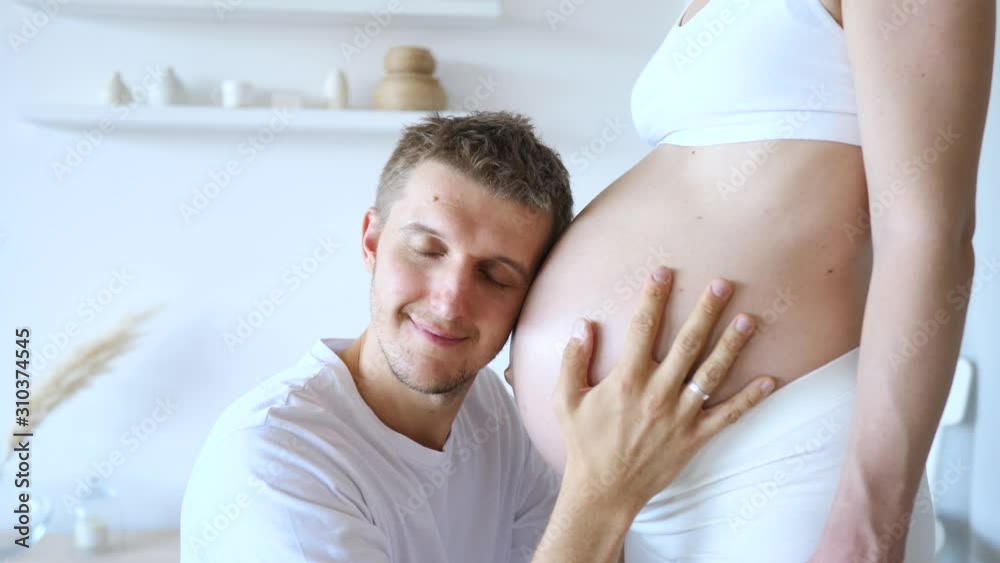 Happy Man Kissing Belly Of His Pregnant Wife. Happy Man Kissing Belly Of His Pregnant Wife.