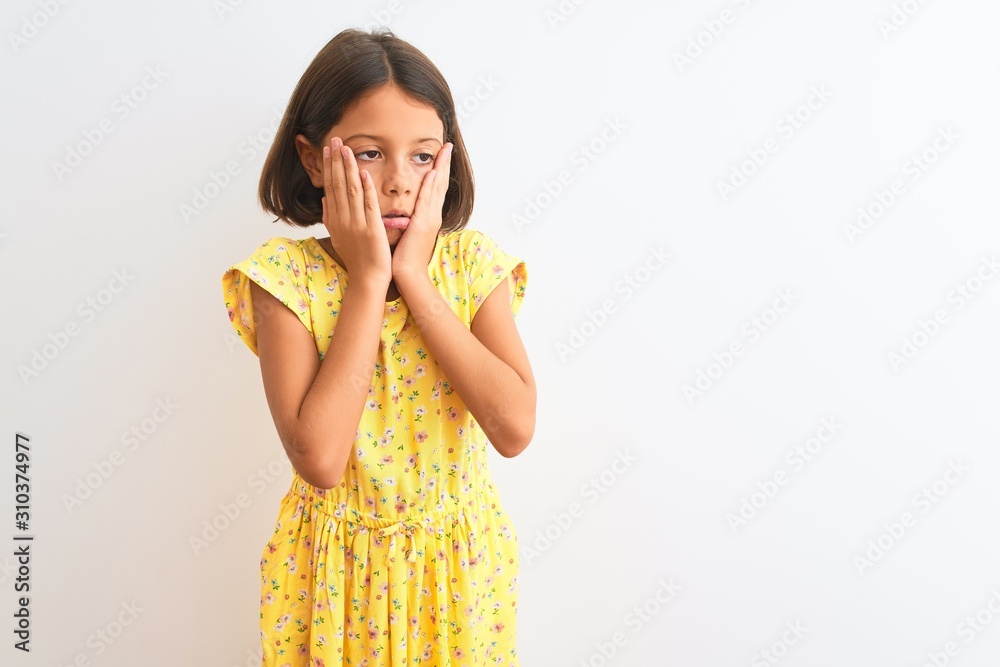 Young beautiful child girl wearing yellow floral dress standing over isolated white background Tired hands covering face, depression and sadness, upset and irritated for problem Young beautiful child girl wearing yellow floral dress standing over isolated white background Tired hands covering face, depression and sadness, upset and irritated for problem