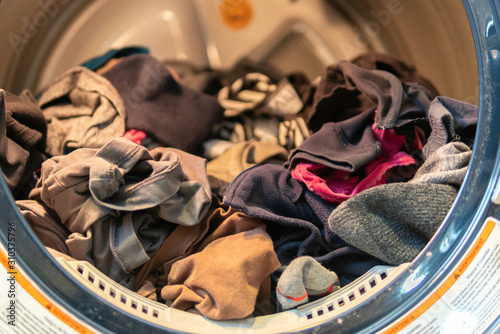 Fresh clean clothes in a dryer after wash
