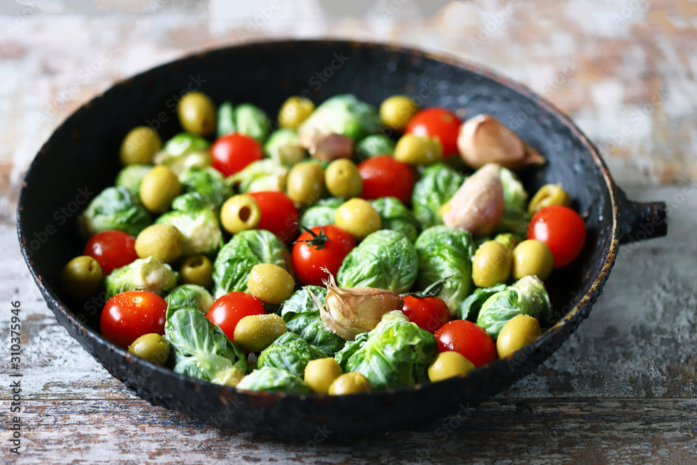 Brussels sprouts with vegetables and herbs in a pan. Cooking Brussels sprouts. Vega food. Selective focus. Brussels sprouts with vegetables and herbs in a pan. Cooking Brussels sprouts. Vega food. Selective focus.