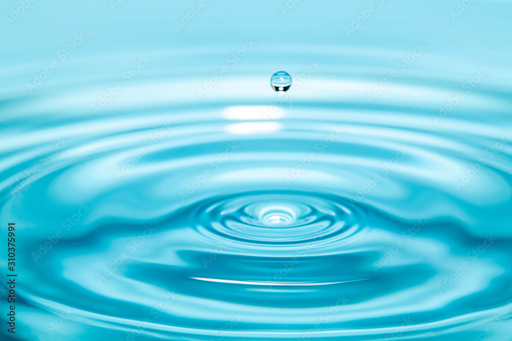 Closeup Water drop falling on the surface of the water and beautiful circular wave ripple, fresh natural mineral water drink water concept Closeup Water drop falling on the surface of the water and beautiful circular wave ripple, fresh natural mineral water drink water concept
