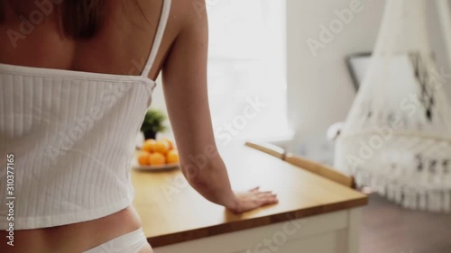 Beautiful sexy woman in white lingerie play with oranges at white kitchen photo