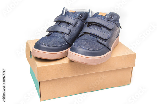 Children shoes sneakers on shoe cardboard box, isolate on white background.