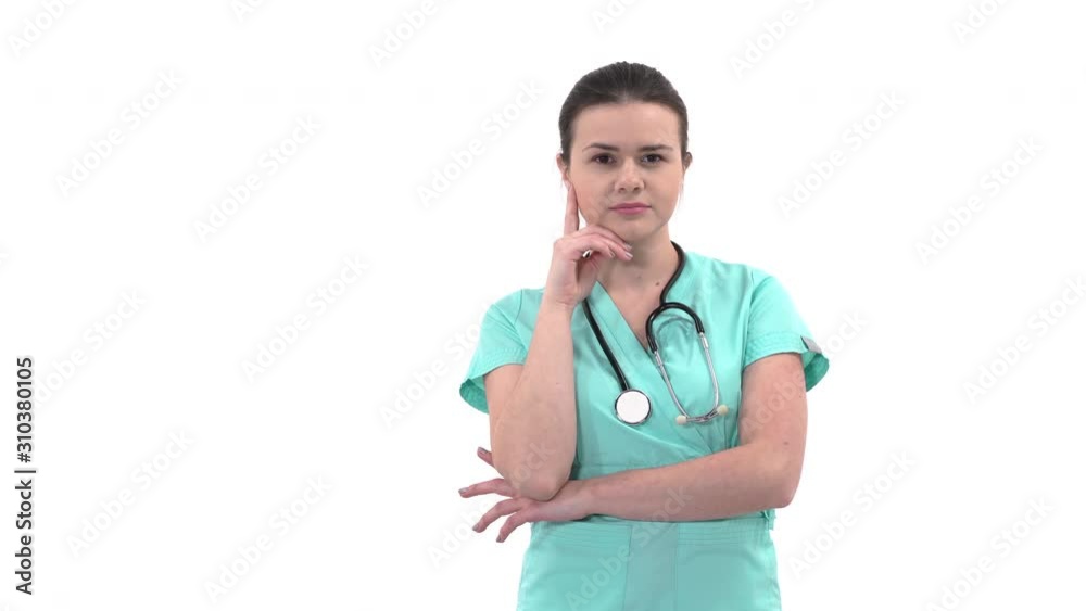 Young Caucasian female doctor wearing stethoscope thinking and putting hand to her face. Doctor expressing emotions by gestures. Isolated, on white background Young Caucasian female doctor wearing stethoscope thinking and putting hand to her face. Doctor expressing emotions by gestures. Isolated, on white background