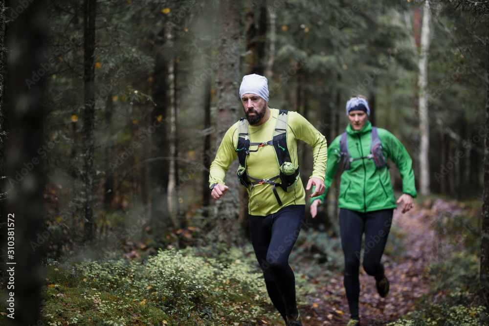 Man and woman running in forest Man and woman running in forest