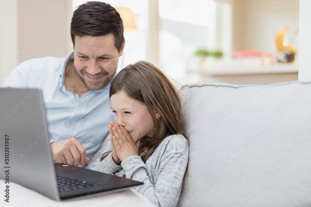 Father with daughter using laptop at home