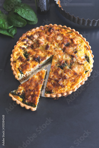 freshly bake  leek bacon spinach quiche on dark blue background with copy space, vertical,  top view