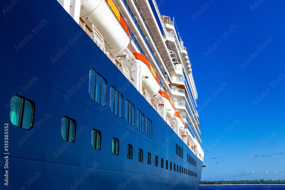 A view of a large cruise ship docked along the waterfront of Bahamas. A view of a large cruise ship docked along the waterfront of Bahamas.