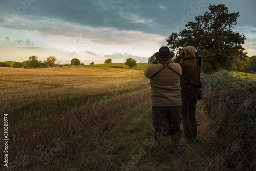 Two hunters looking at field photo