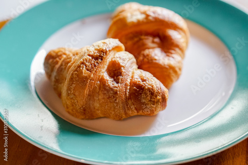Fresh croissant is served on ceramic plate