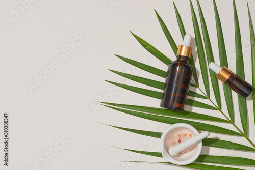 Spa concept with, massage salt in spoon and bottles of essential oil with small leave photo