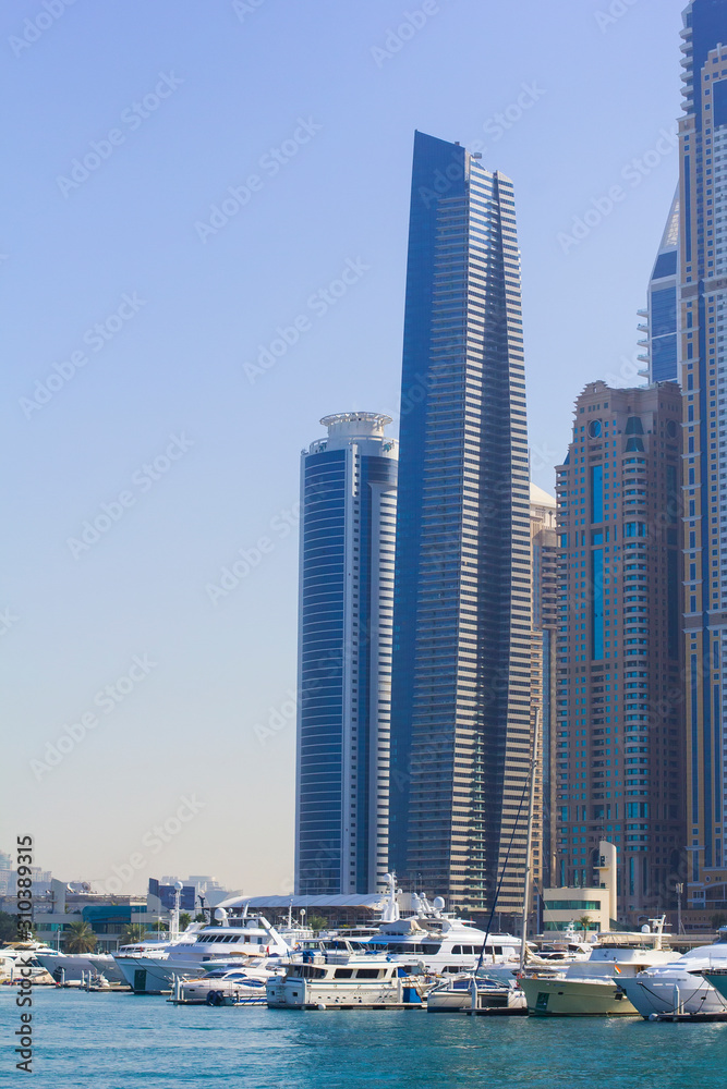 Fototapeta premium background view from the water to the Dubai Marina maritime entrance for water transport, and a group of modern skyscrapers, Dubai, UAE