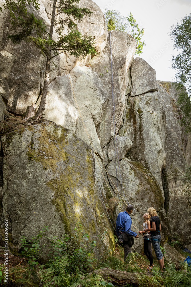 Three people preparing for rock climbing Three people preparing for rock climbing