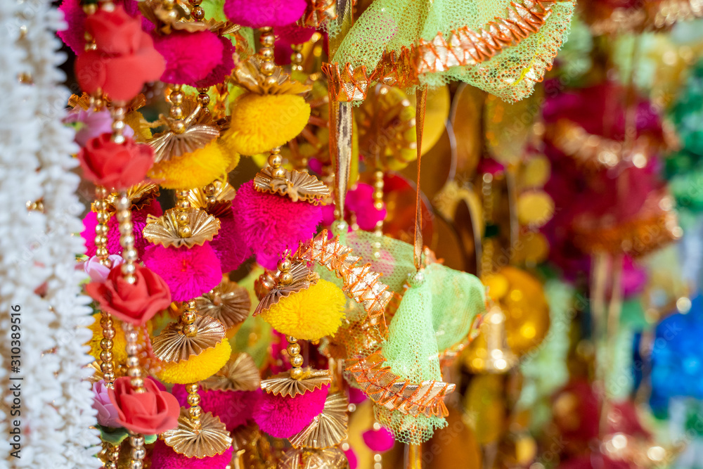 Colorful fabric decorations on display for sale in Chandi Chowk Old Delhi. These flowers, beads and bells designs are popular in weddings, festivals and events.