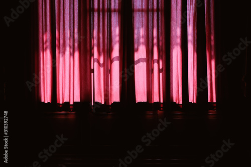 sunlight on red curtain. fabric folds in home interior
