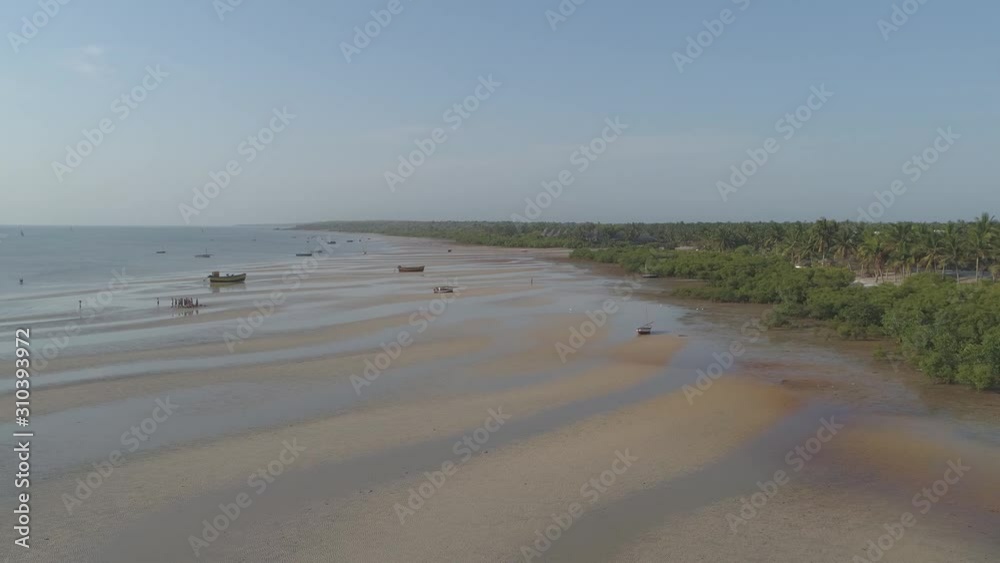 Scenic aerial push in shot of fisherman gathering at low tide on African beach Scenic aerial push in shot of fisherman gathering at low tide on African beach