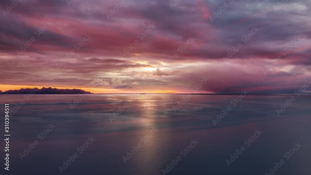 Spectacular sunset above the fjord on the island of Andoya, Norway. The sky is lit by pink, red and violet, last rays piercing through the thick clouds. Spectacular sunset above the fjord on the island of Andoya, Norway. The sky is lit by pink, red and violet, last rays piercing through the thick clouds.