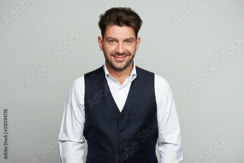 Handsome man is smiling isolated on grey background