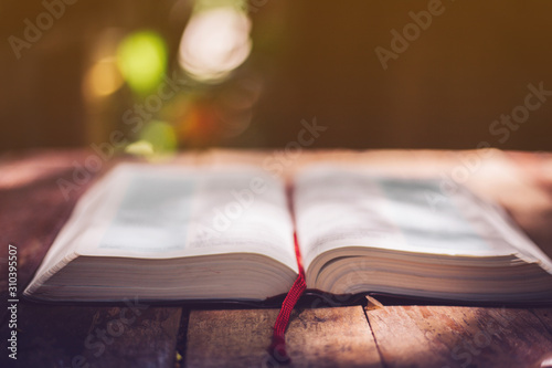 Soft focus Open holy bible on wood table with copy space.