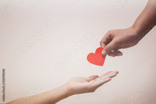 Soft focus Hand giving a red heart 