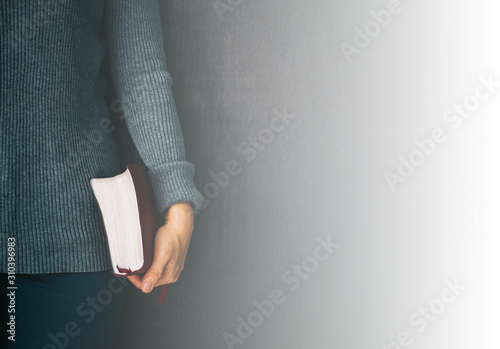 Woman holding the bible in hands and pray with copy space.