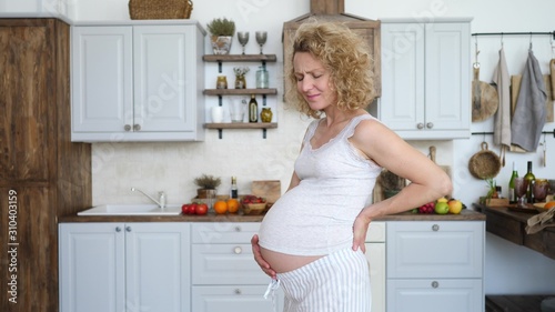 Pregnant Woman Suffering From Backache And Holding Her Back