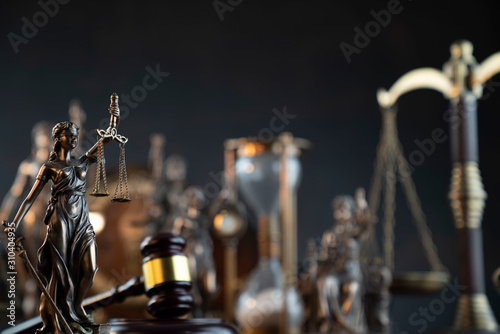 Law theme. Gavel of the judge, Themis statue and scale of justice on gray background.