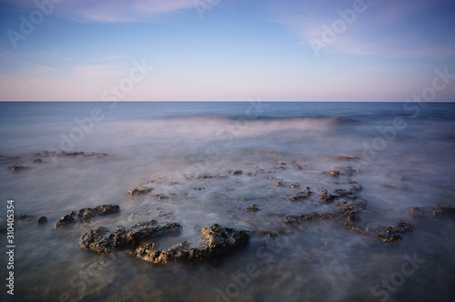 the atmosphere of the beach or the coast before the afternoon with calm waves and sunny weather set against the background of the high seas and mountains or plateaus