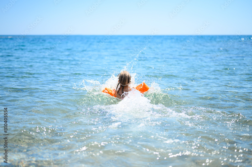 little girl having fun at summer vacation in sea