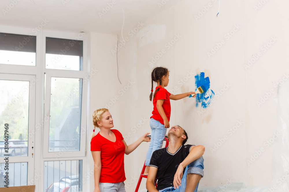 Fototapeta premium Young happy family doing repairs in the house for sale. Concept of house selling. Home repair.