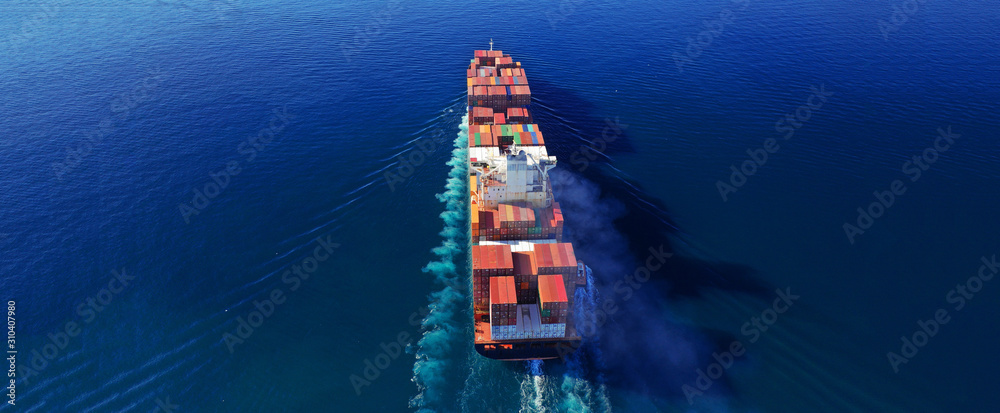 Aerial drone photo of industrial cargo container carrier cruising the open ocean deep blue sea