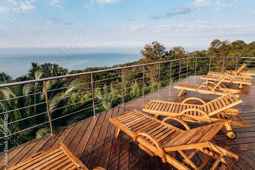 Wooden deck chairs in the hotel with scenic views of the ocean or sea Fototapet