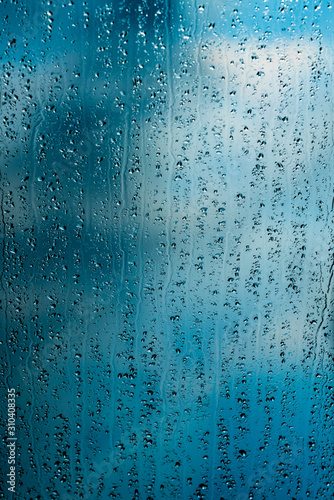 heavy rain drops on blue window photo