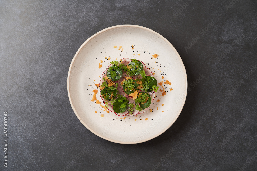 Ταπετσαρία Fresh beef tartare dish with fresh vegetables in white plate