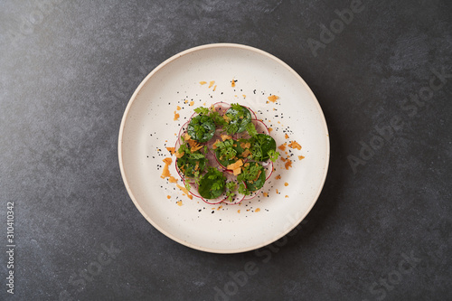 Fototapeta Naklejka Na Ścianę i Meble -  Fresh beef tartare dish with fresh vegetables in white plate