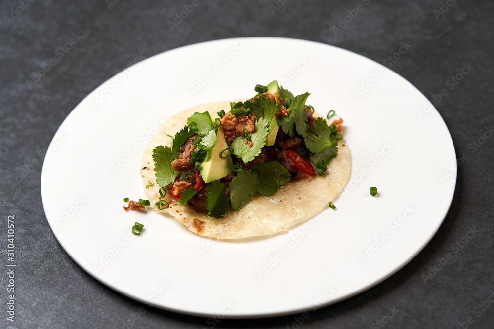 Mexican tacos with beef, tomatoes, avocado, chilli and onion Mexican tacos with beef, tomatoes, avocado, chilli and onion