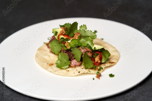 Mexican tacos with beef, tomatoes, avocado, chilli and onion