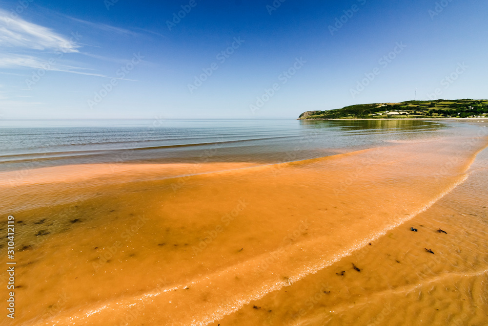 Unusual seascape from Red Wharf Bay on the Isle of Anglesey, with an orange, yellow substance brought up from the seabed during a hot summer Unusual seascape from Red Wharf Bay on the Isle of Anglesey, with an orange, yellow substance brought up from the seabed during a hot summer