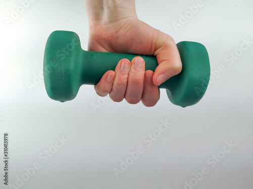 Hand holding a dumbbell on a white background for weight loss and weight lifting, increasing strength and improving yourself while working out