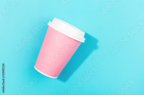 Pink take out cup on aqua color background.