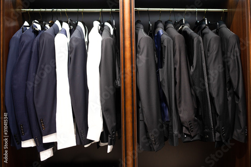 Many men's suits on a hanger in the store