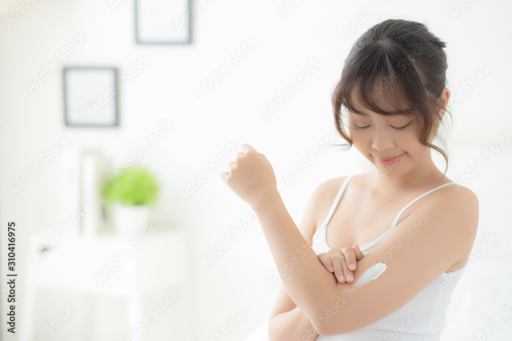 Beautiful portrait young asian woman smile applying sunscreen cream or lotion on skin care at bedroom, beauty asia girl using makeup and cosmetic for smooth and silky, wellness and health concept. Beautiful portrait young asian woman smile applying sunscreen cream or lotion on skin care at bedroom, beauty asia girl using makeup and cosmetic for smooth and silky, wellness and health concept.