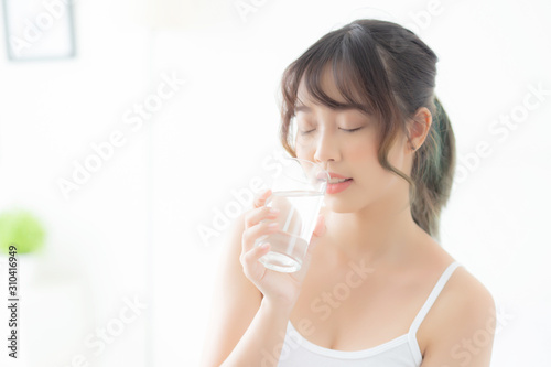 Beautiful portrait young asian woman caucasian smiling with nutrition thirsty and drinking glass of water mineral with fresh and happy  asia girl diet for healthy care and wellness  lifestyle concept.