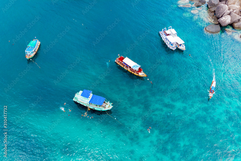 Top view of boats and divers in blue water.